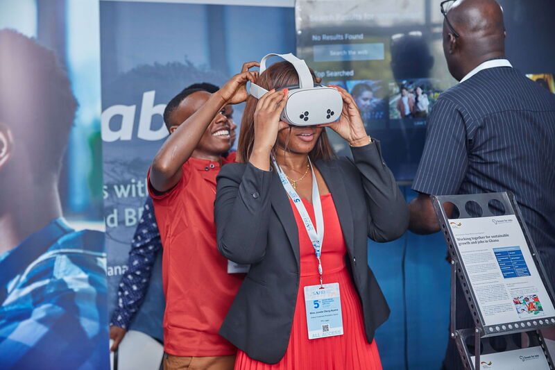 Eine Frau, die zu Demonstrationszwecke eine VR-Brille aufgezogen bekommt.